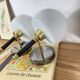 Pair of wall sconces with brass torch and white glass globe.