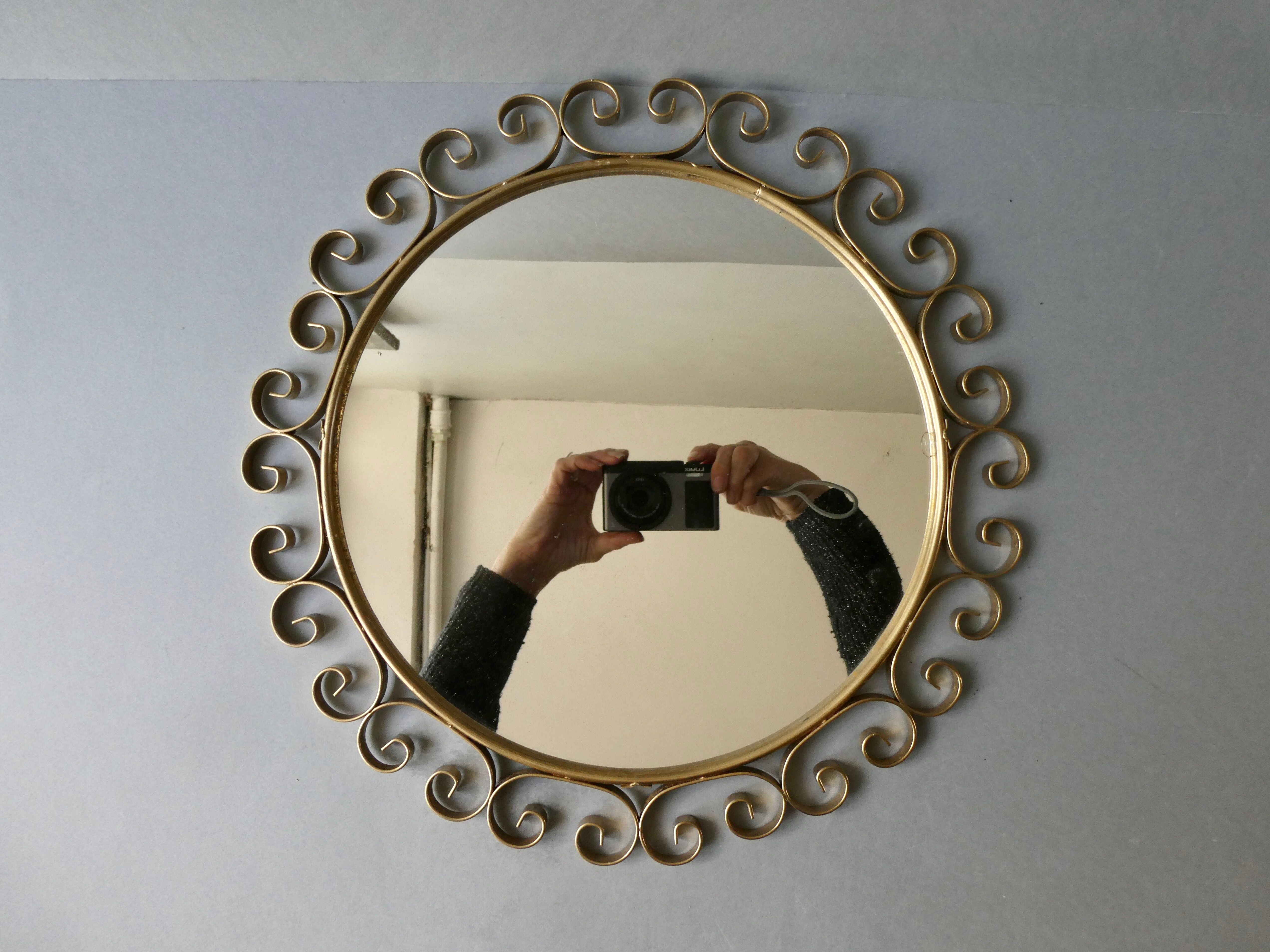 Round mirror with golden metal arabesques