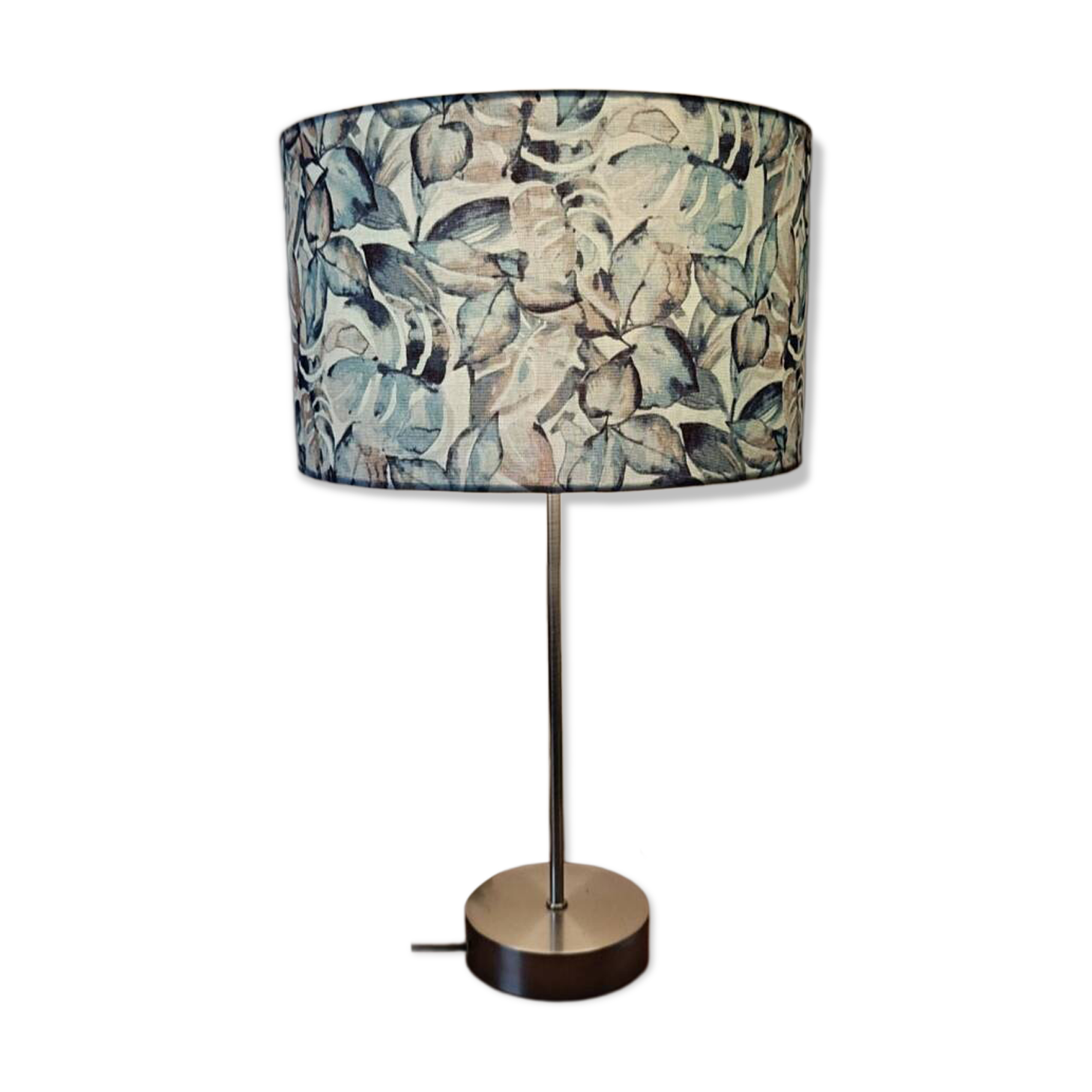Table lamp with chrome stem, tropical plant shade.