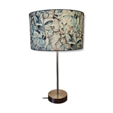 Table lamp with chrome stem, tropical plant shade.