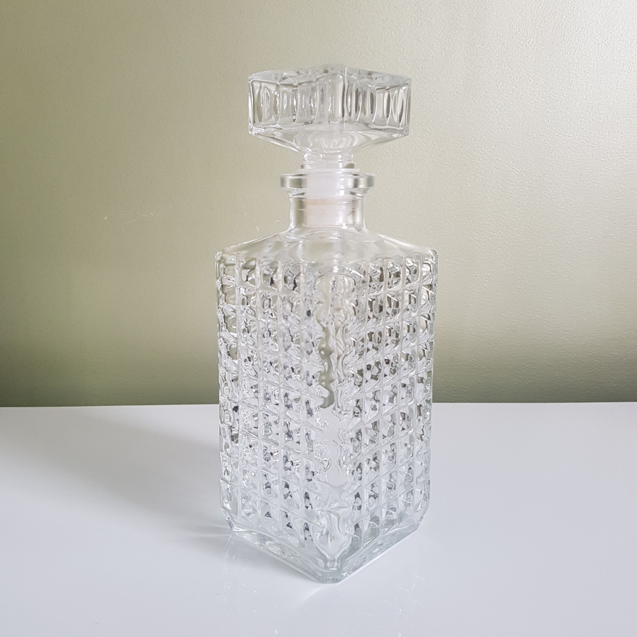 A square glass whiskey decanter