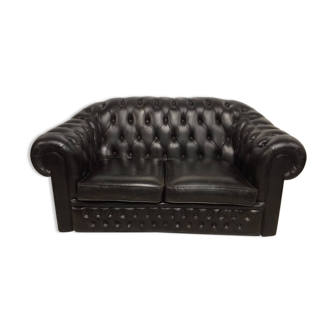 Two-seater black leather chesterfield sofa
