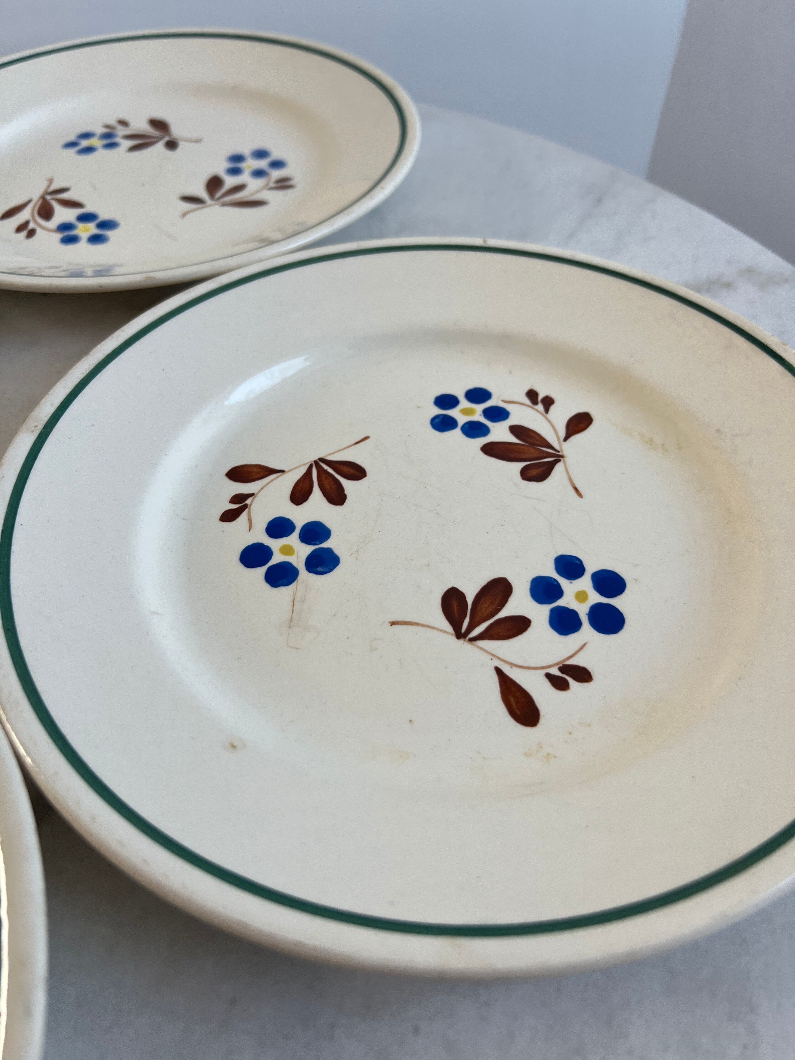 Set of 4 small flat plates with floral designs.