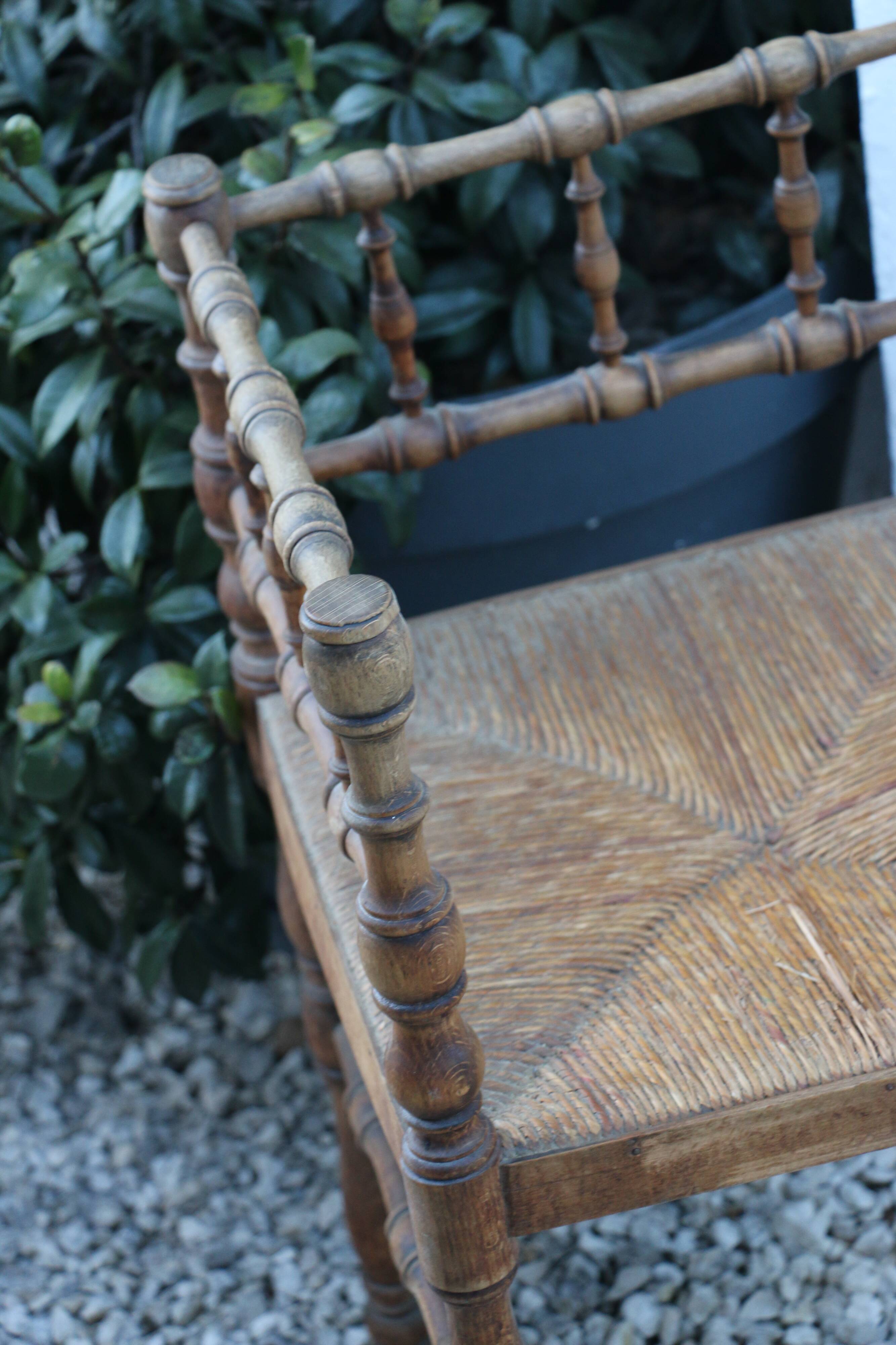 Antique corner chair in wood bamboo style seated in straw