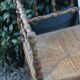 Antique corner chair in wood bamboo style seated in straw