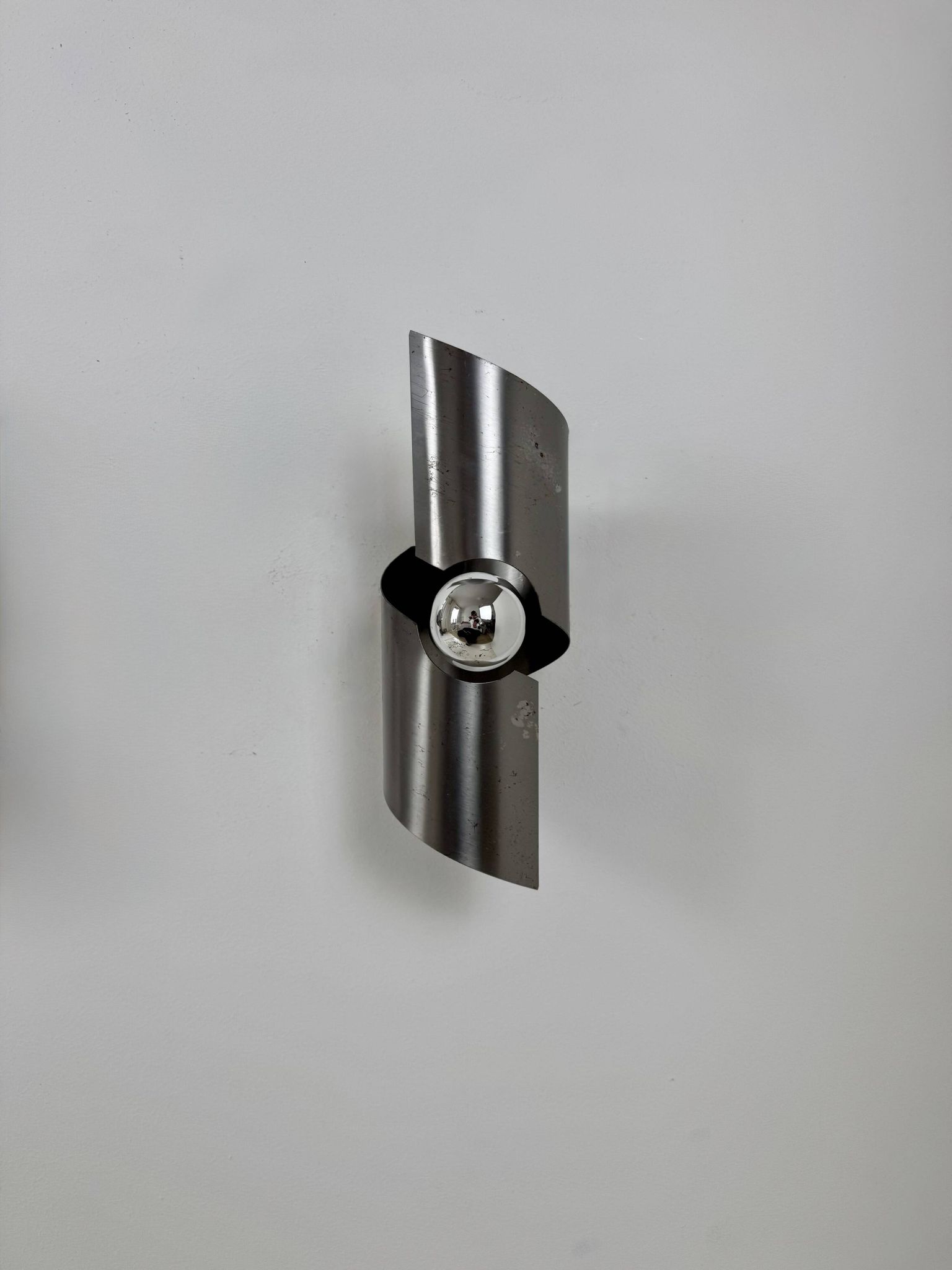 Pair of vintage wall lights, curved patinated steel, France, 1970.