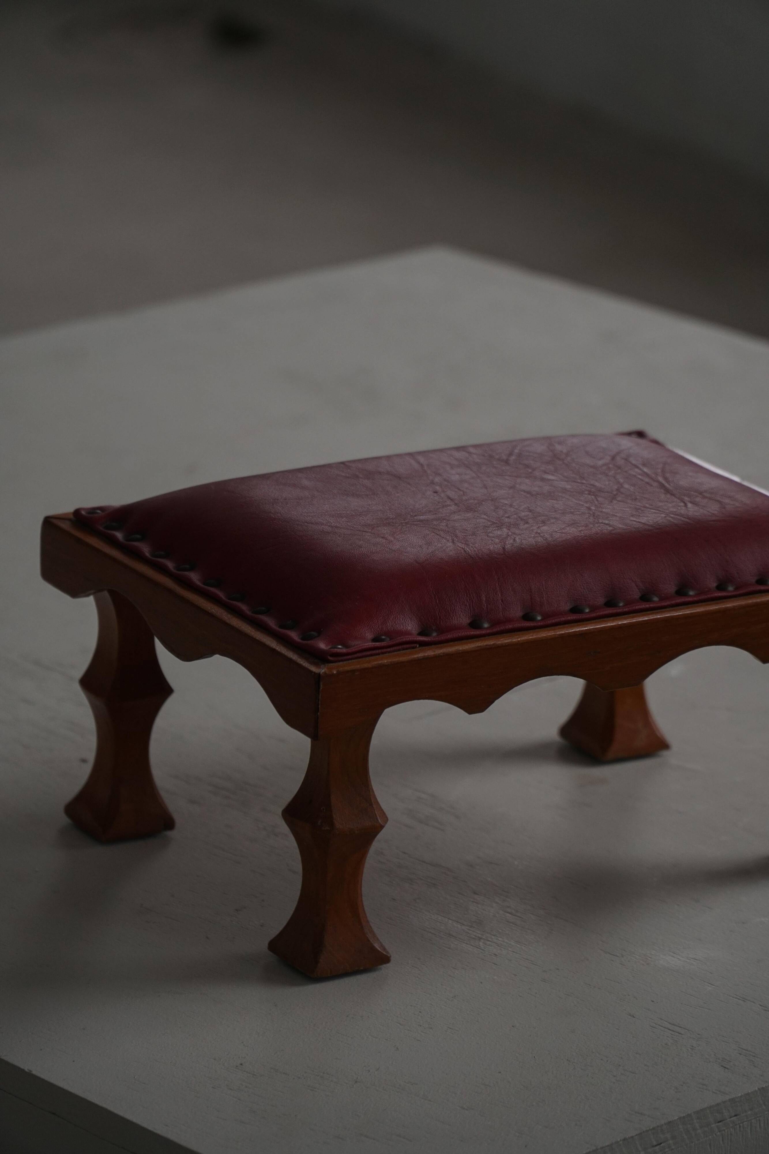 Danish sculpted oak stool from the mid-20th century with a red leather seat, 1950s.