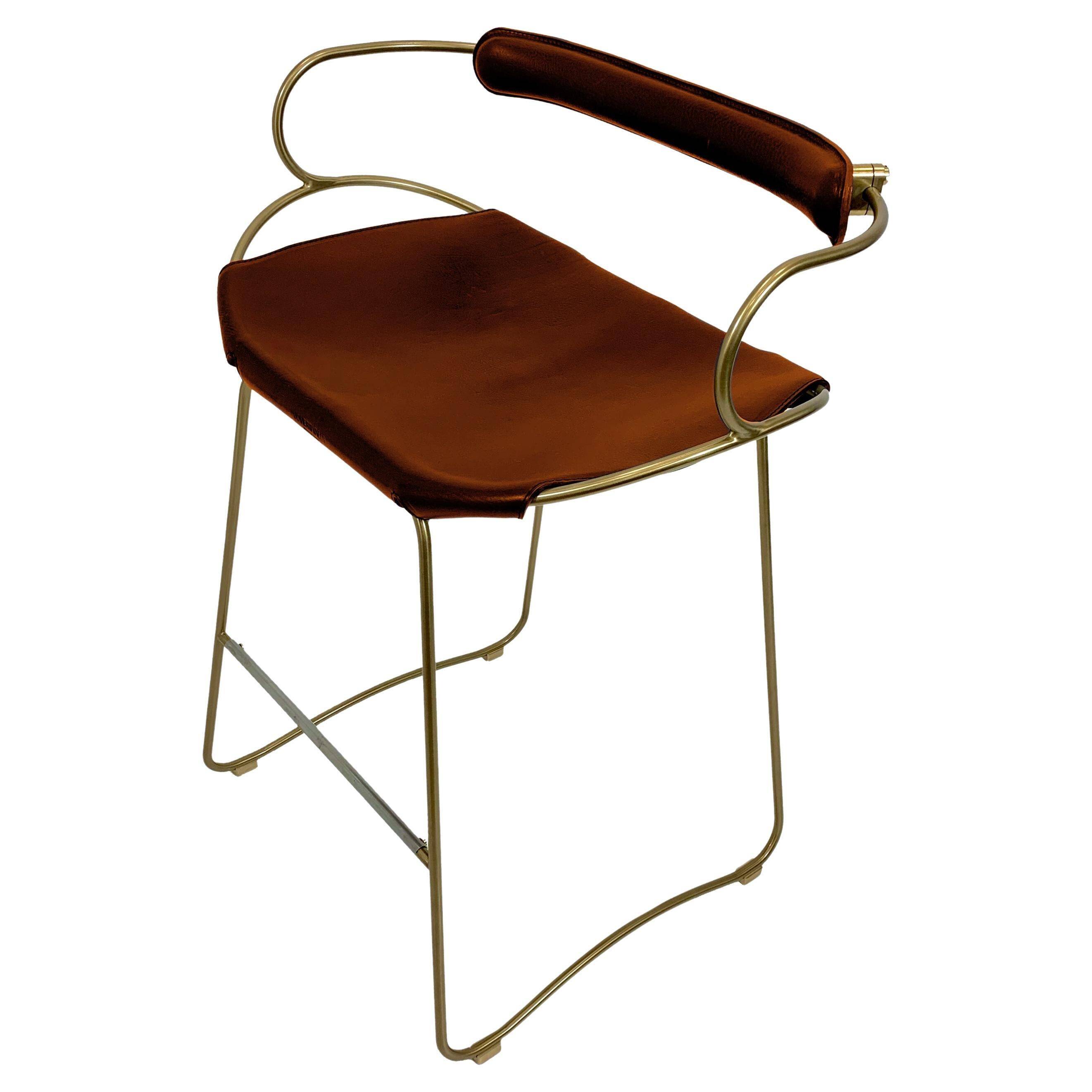 Contemporary sculptural bar stool with a metal back in aged brass and cognac leather.