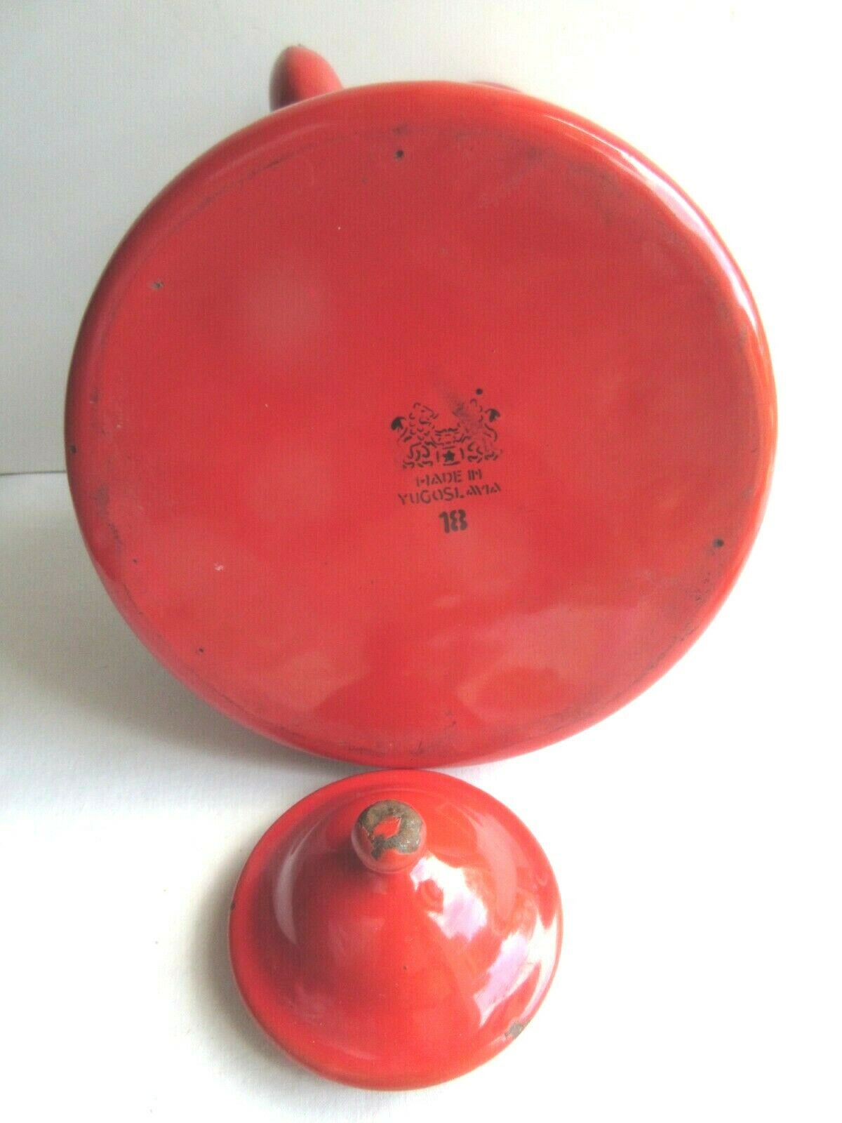 Old vintage kettle in red enamelled sheet metal, with white polka dots
