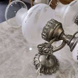 Pair of vintage wall sconces in brass, porcelain, and frosted glass.