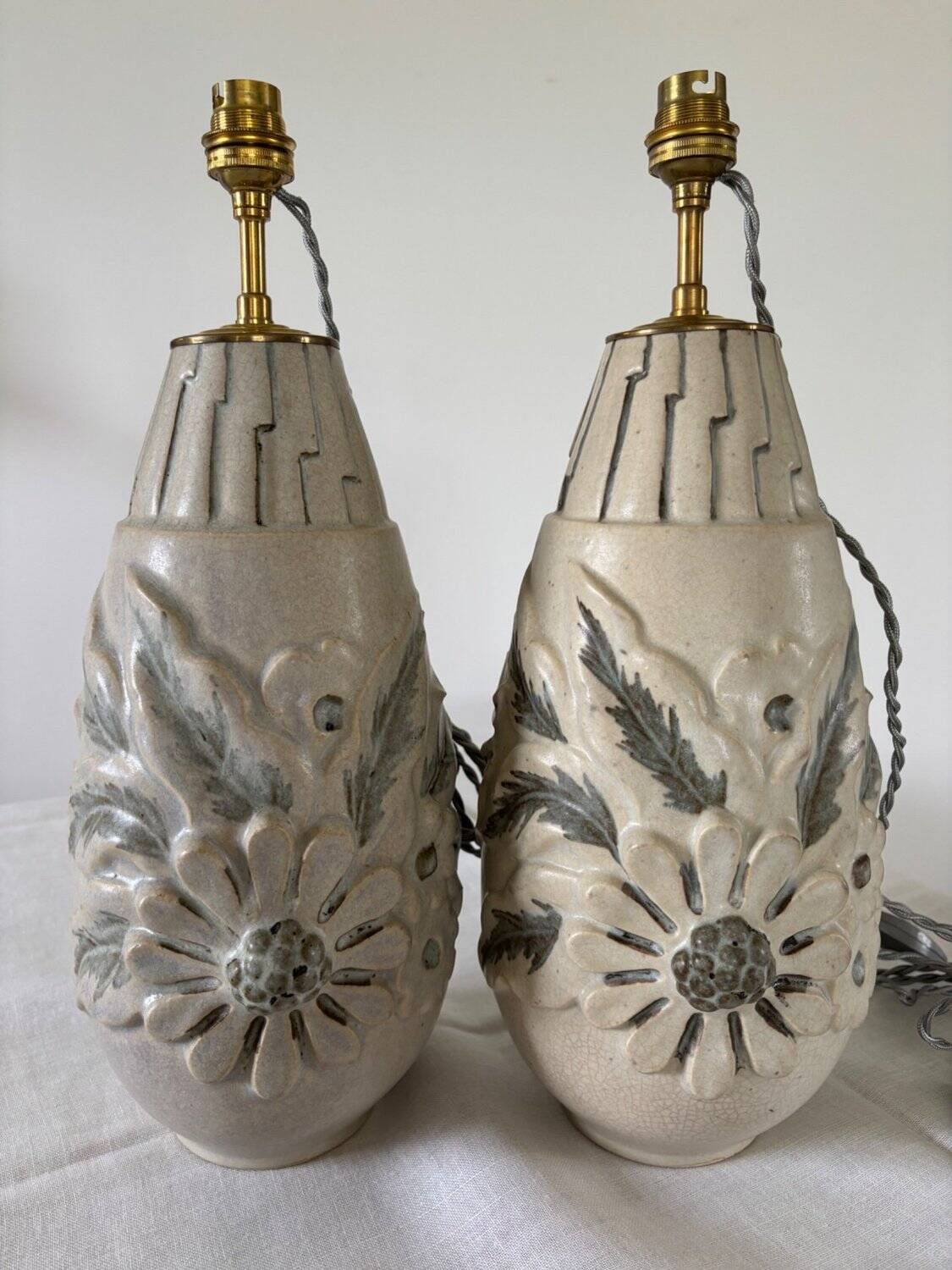 Pair of white glazed stoneware lamp bases, 20th-century floral decoration.