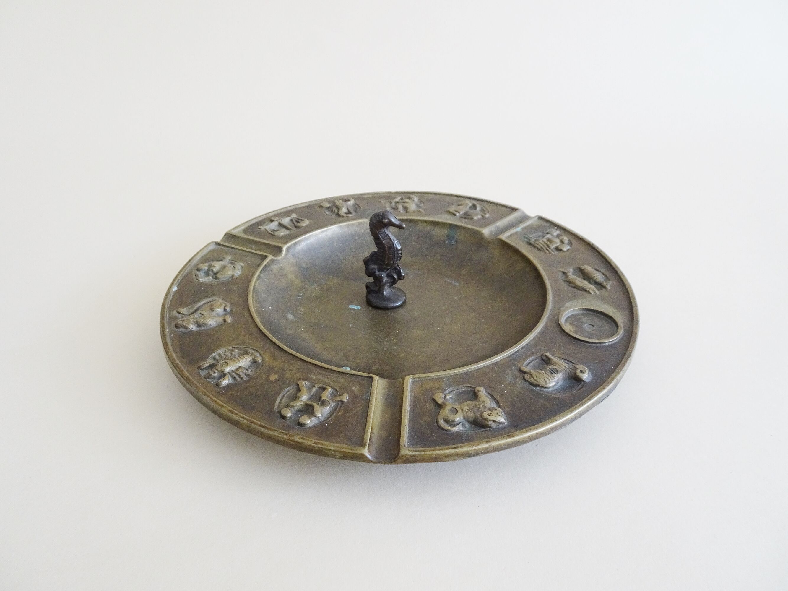 Luxa brass ashtray with zodiac relief and embers killer