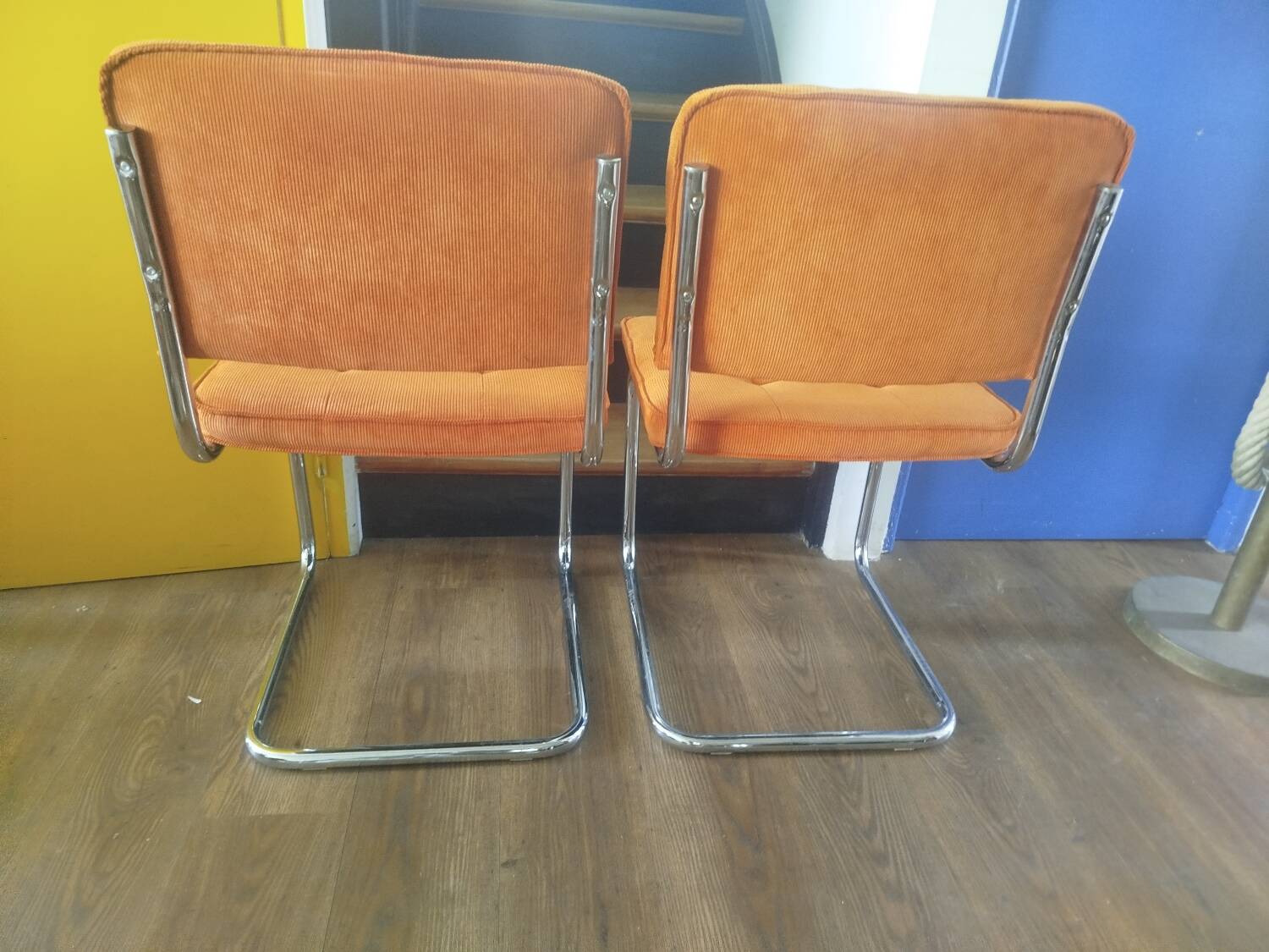 Pair of vintage cantilever chairs in chrome and orange corduroy.