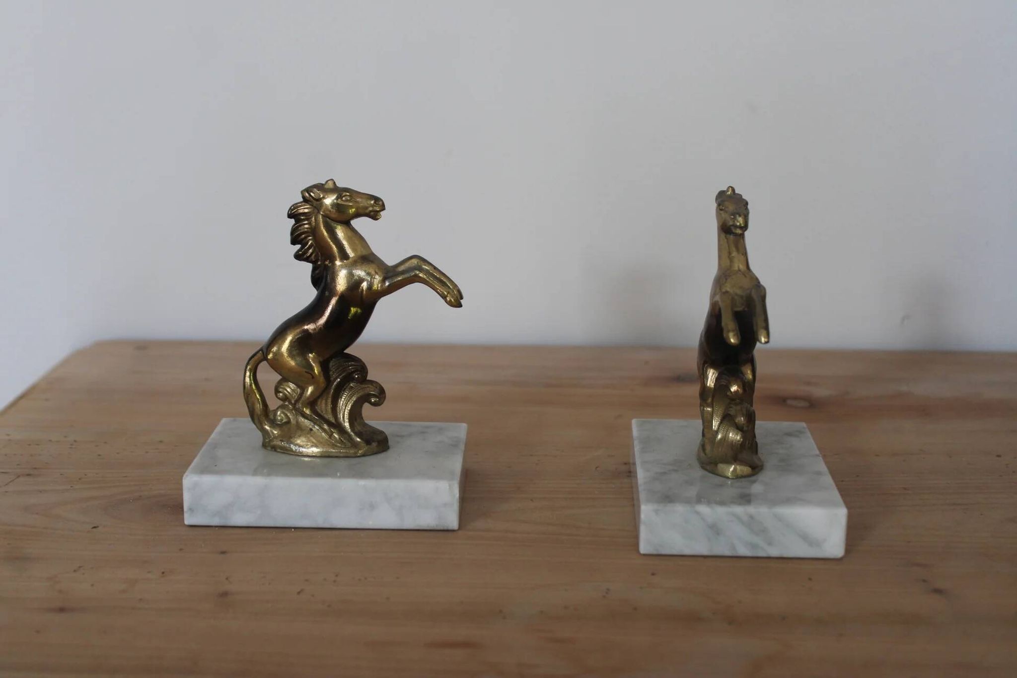 Pair of vintage bookends with rearing horses in gilded metal on marble bases.