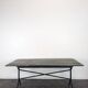 Garden table with a cast iron base and a green painted wooden top.