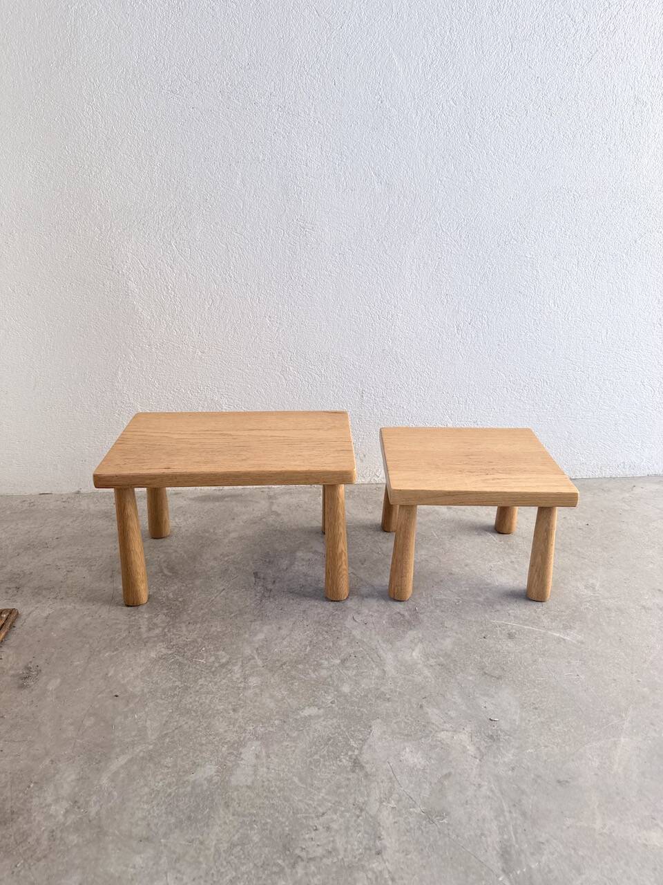 Two stools or small nesting tables in light oak.