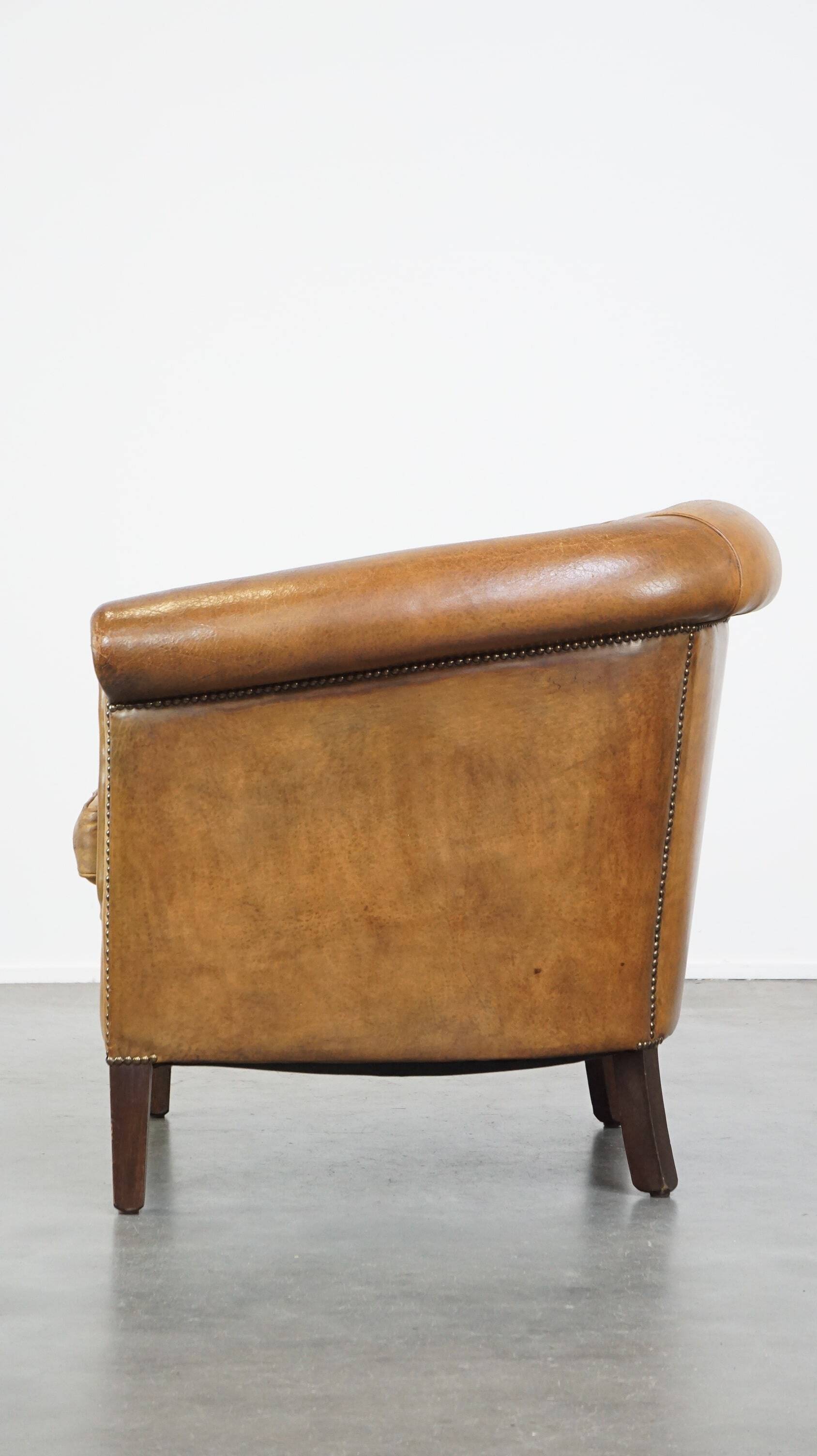 Comfortable, cozy, warm colored sheepskin club chair finished with decorative nails