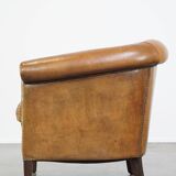 Comfortable, cozy, warm colored sheepskin club chair finished with decorative nails