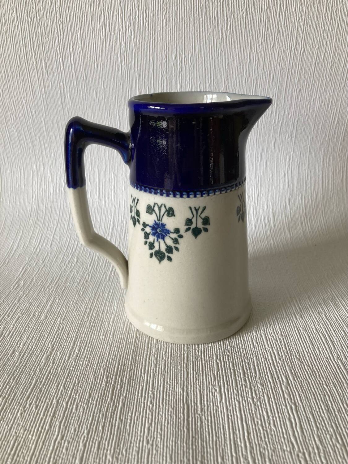 Pichet Saint-Uze en terre d’acier bleu, blanc et à décor floral