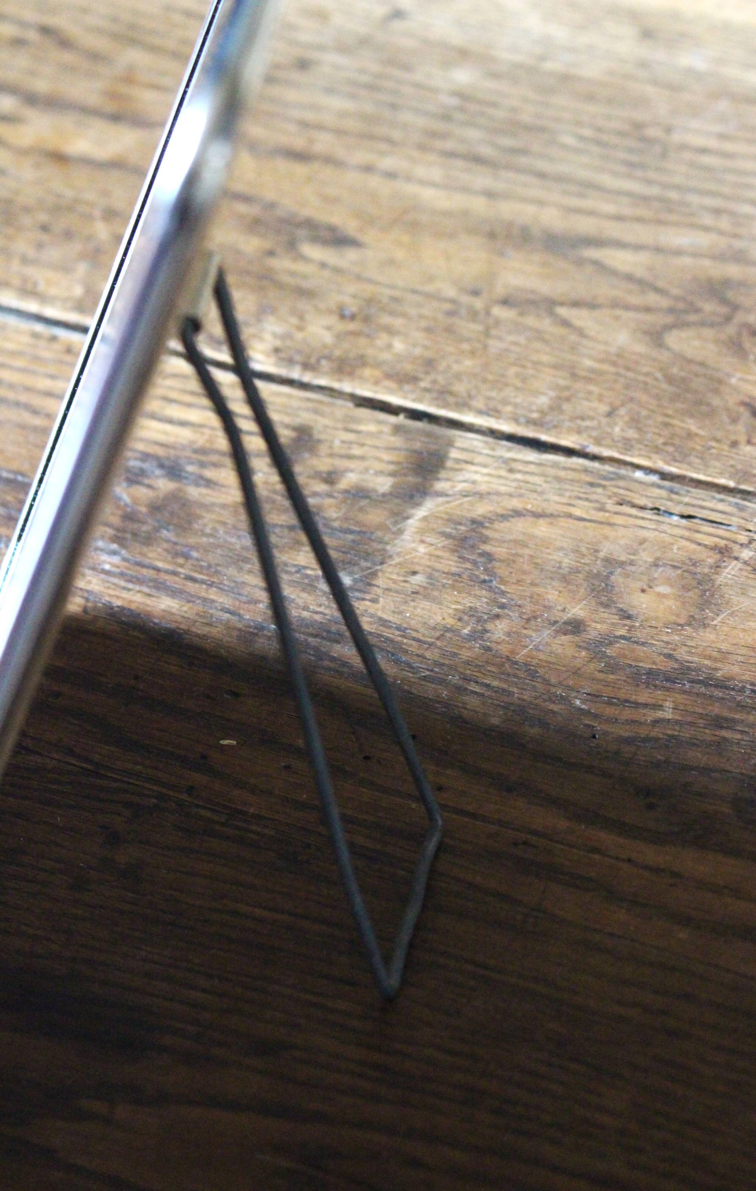 Simple rectangular barber mirror with a stand.