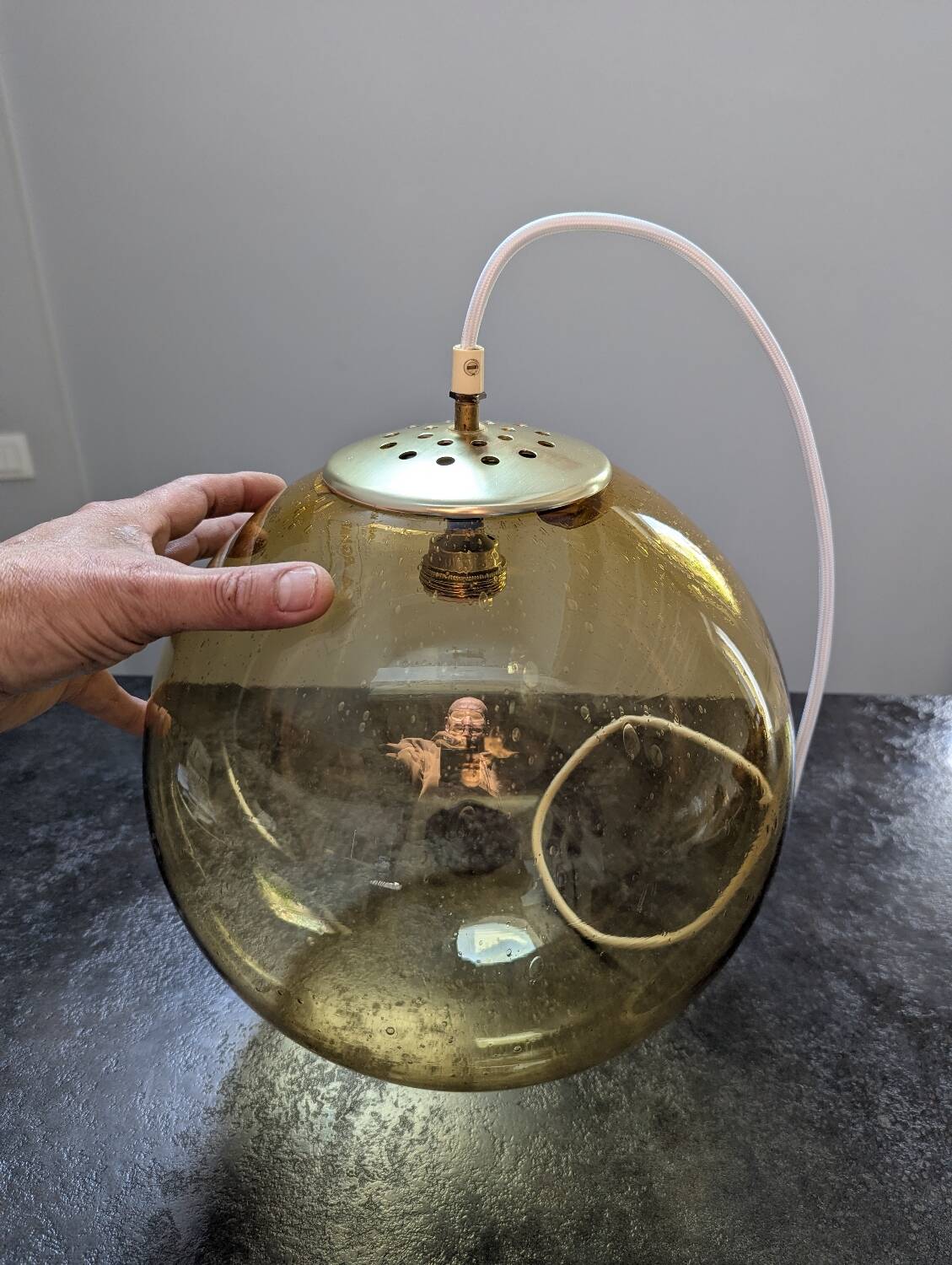Old large and imposing thick glass globe with a bubbled amber colour, vintage.