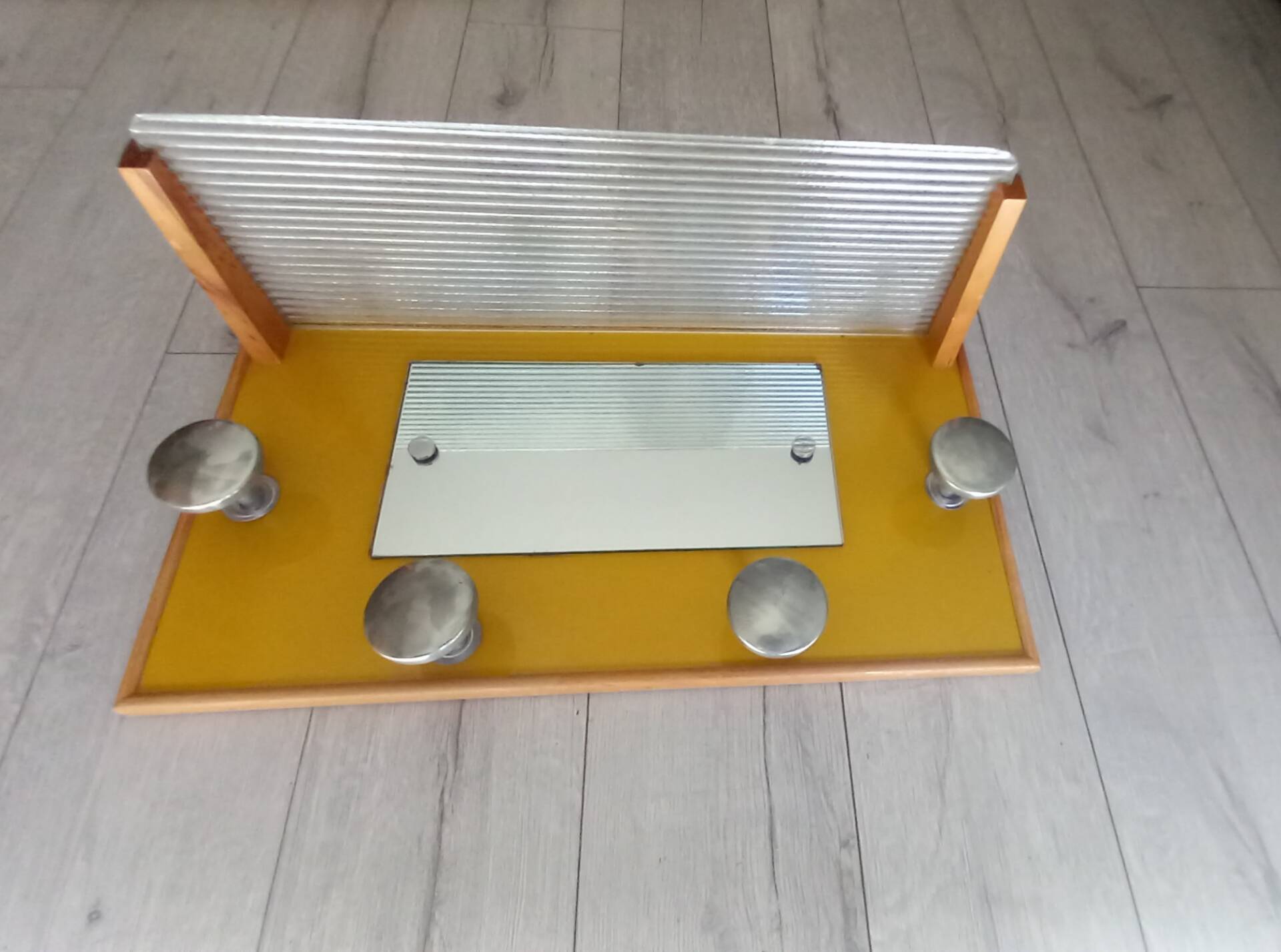 1950s coat rack with mirror, metal hooks, and glass shelf.