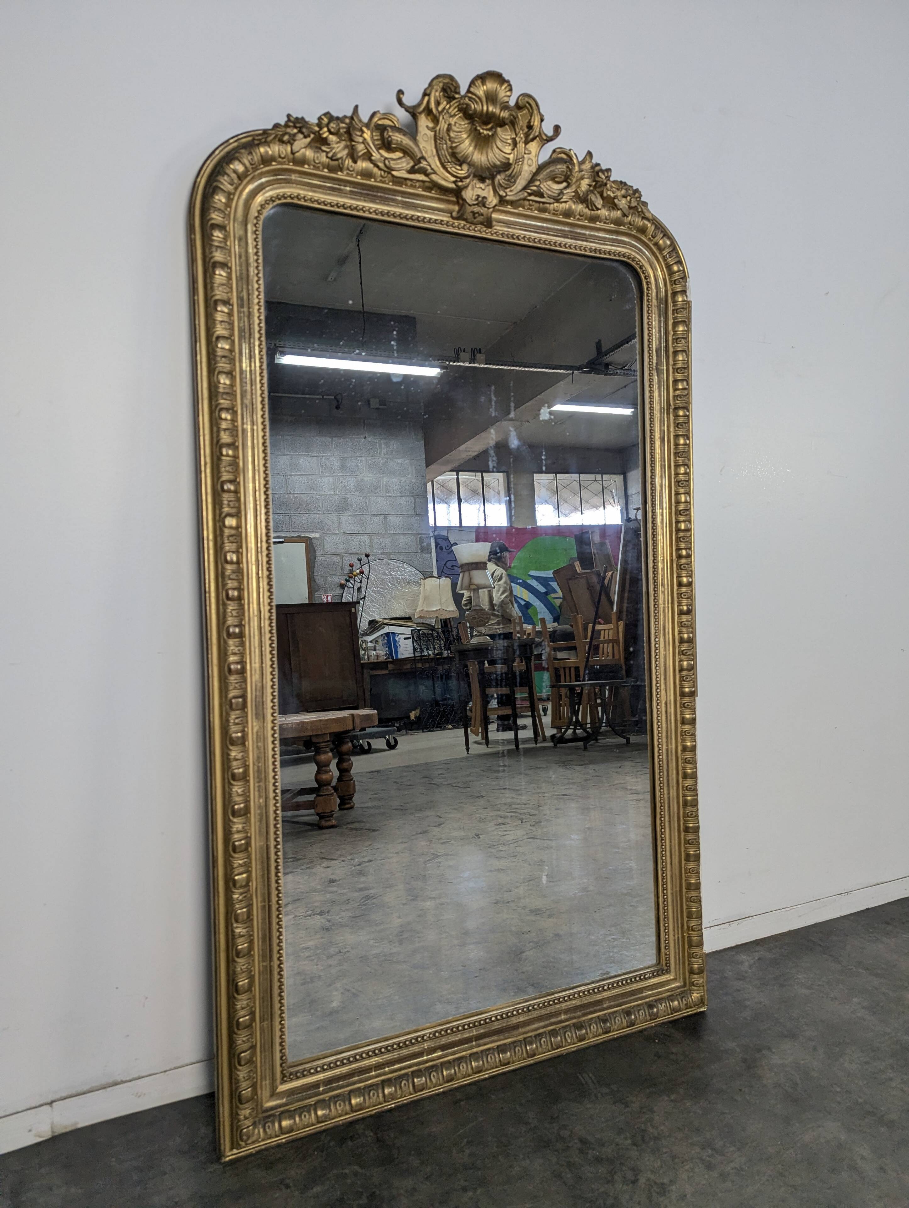Golden mirror from the Napoleonic III era with shells and fluting.