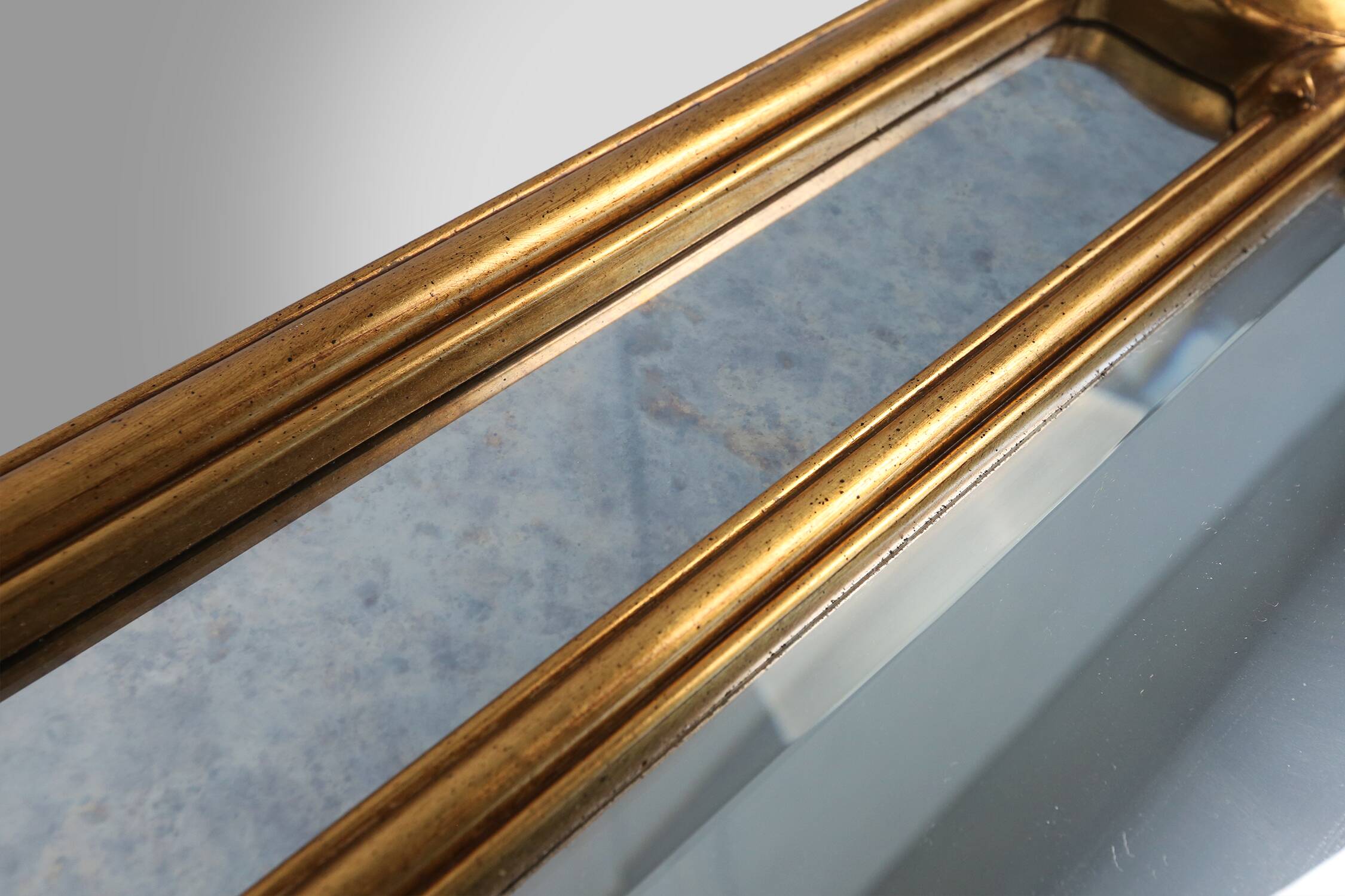 Richly decorated wall mirror in resin with golden ornaments and smoked mirror glass panels, Belgium,