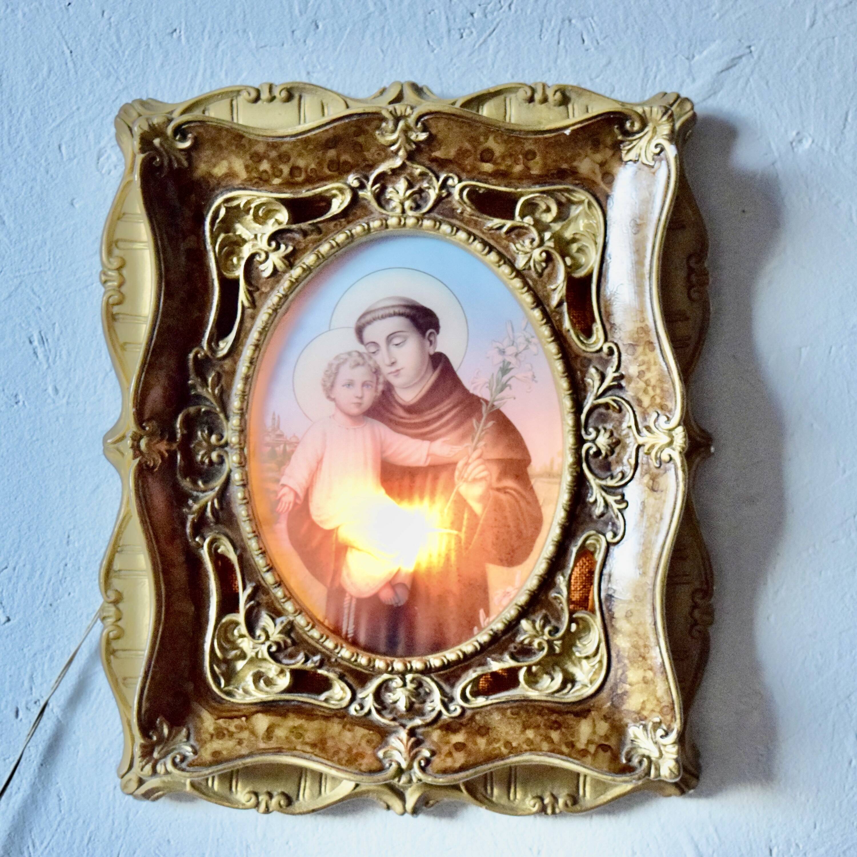 Old religious light frame in gilded stucco and curved glass