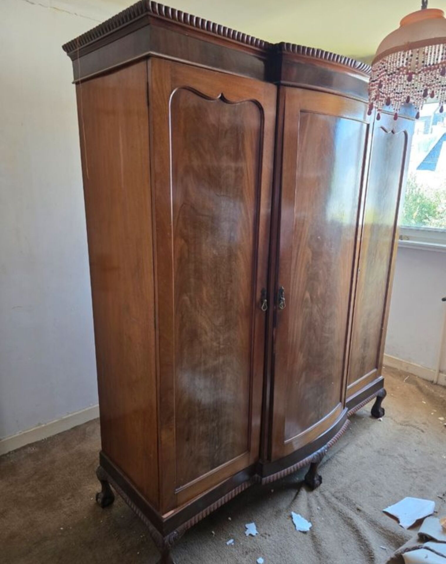 Large English-style wardrobe with a curved front and three doors.