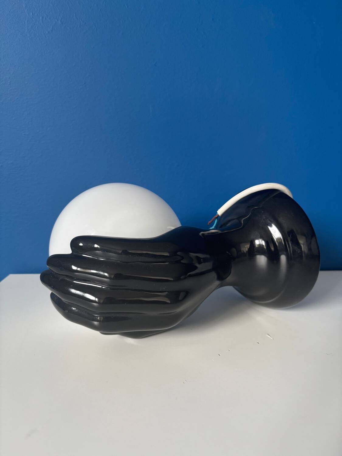 Vintage wall sconce with black hand and white opaline glass globe, 1970s L