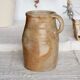 Old rustic stoneware jar with handle