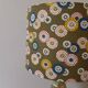Table lamp with light green onyx base, fabric shade with a khaki background.