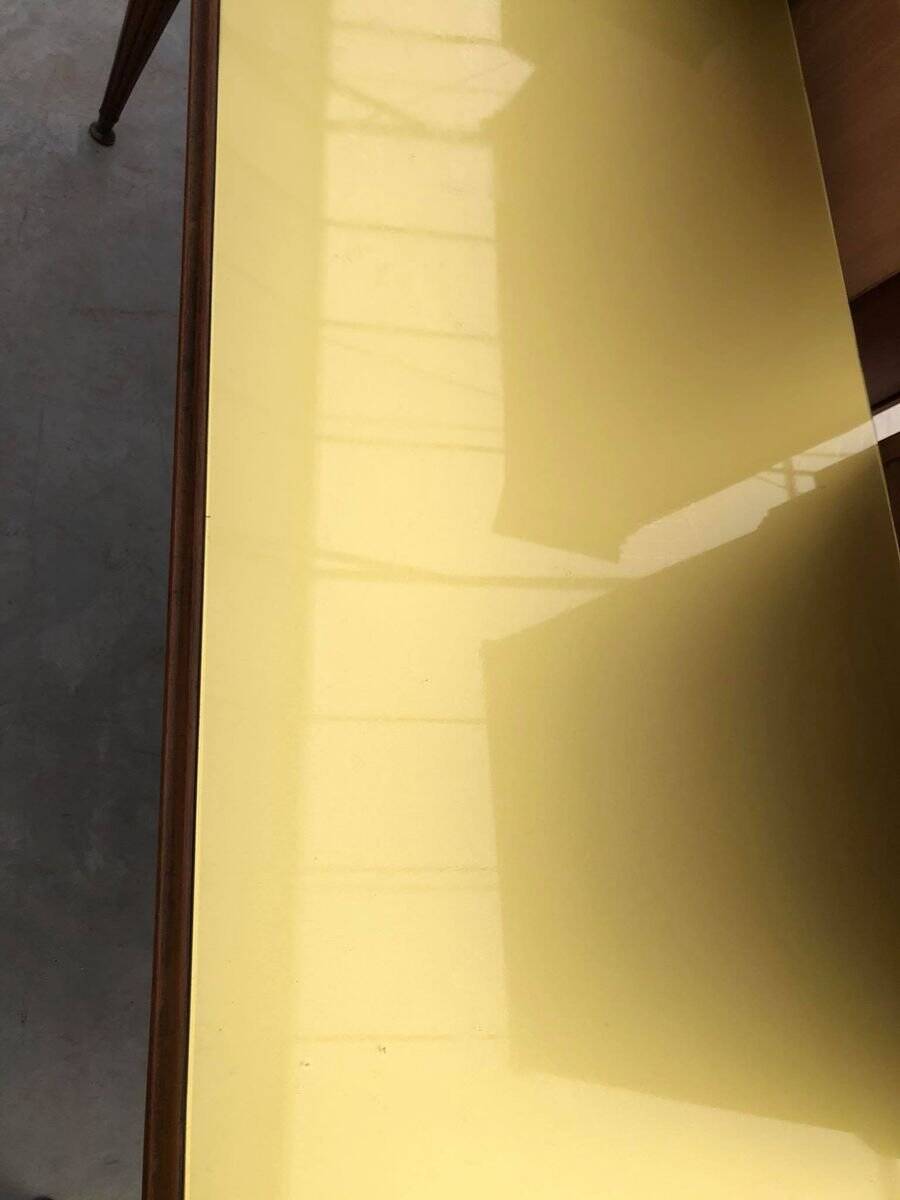 Dining table in the style of Paolo Buffa, made of brown wood with a tinted glass top.