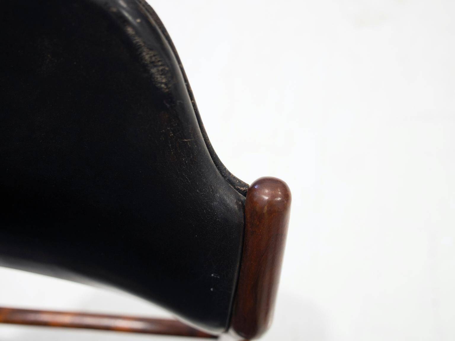 Set of four Arne Vodder chairs in hardwood and black leather.
