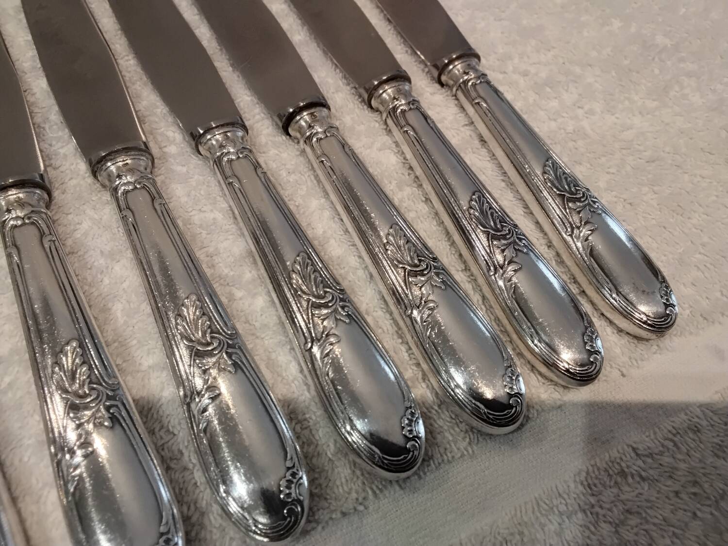 12 silver-plated metal table knives with rocaille ribbon decoration, 25.1 cm
