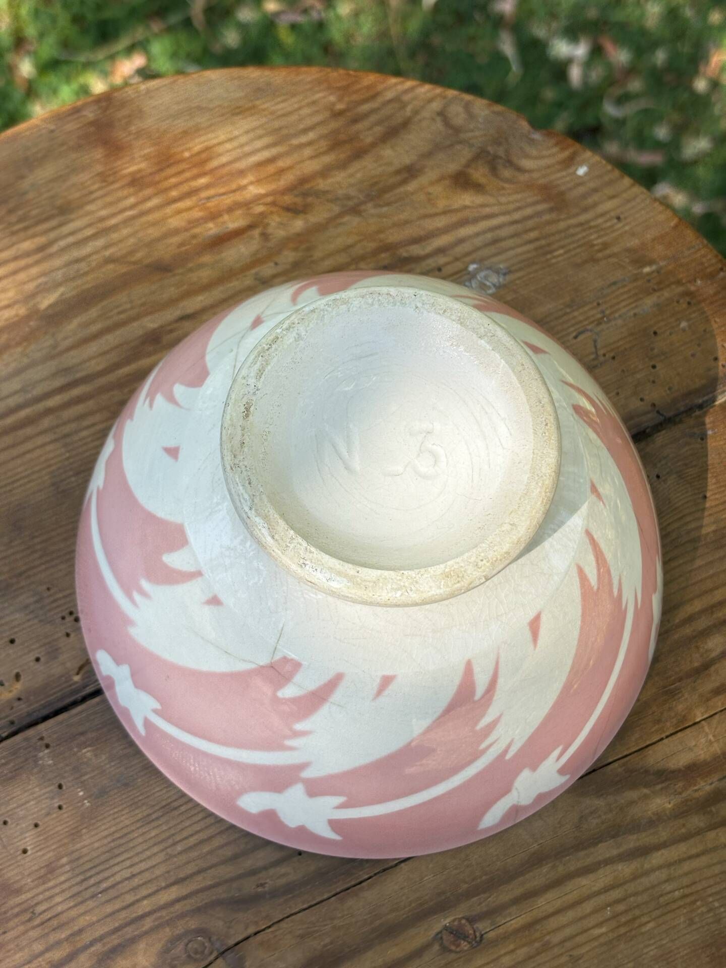 Old footed bowl in earthenware with pink decoration and defects.