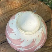 Old footed bowl in earthenware with pink decoration and defects.