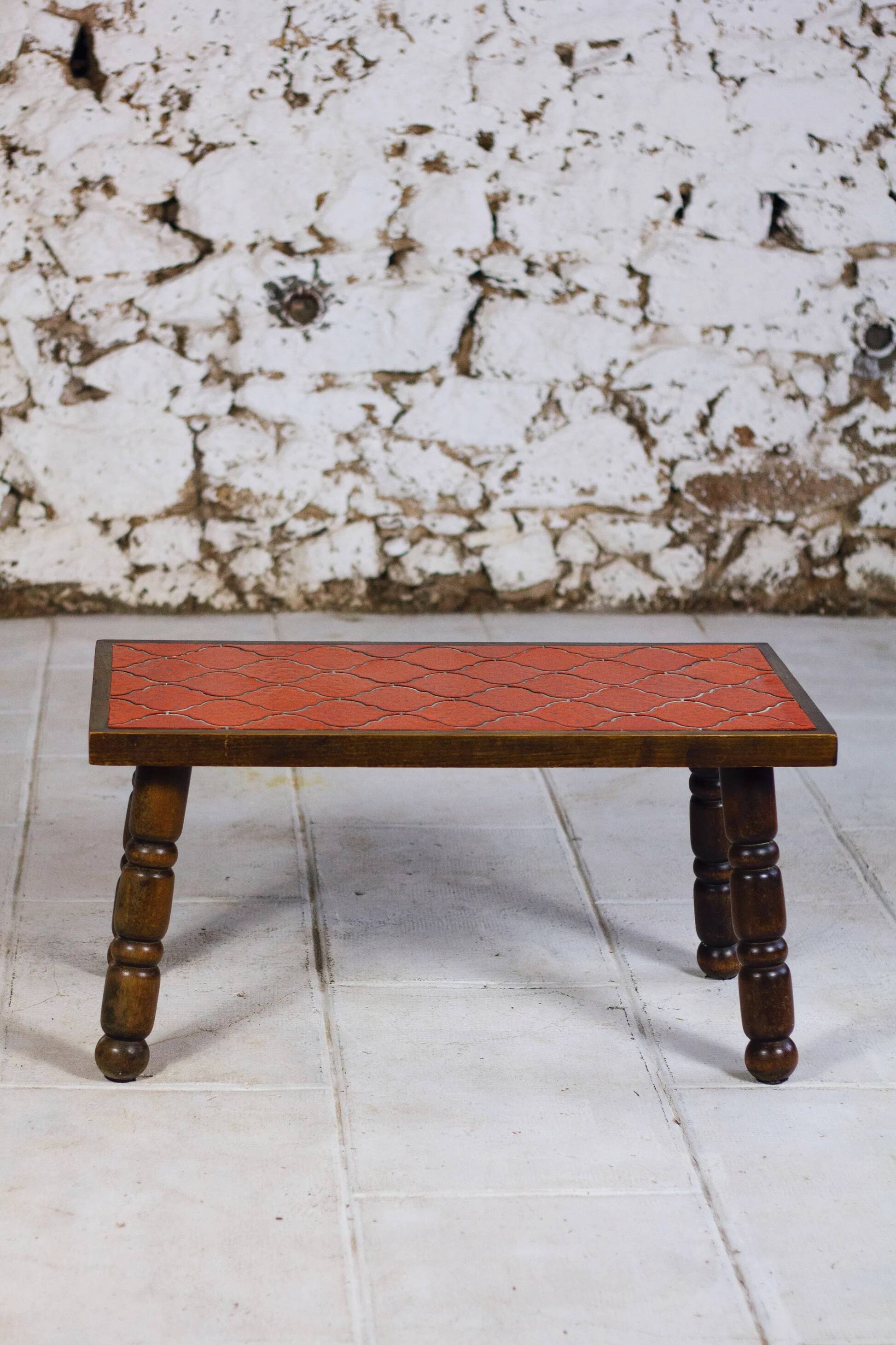 Brutalist coffee table in orange ceramic and solid wood.