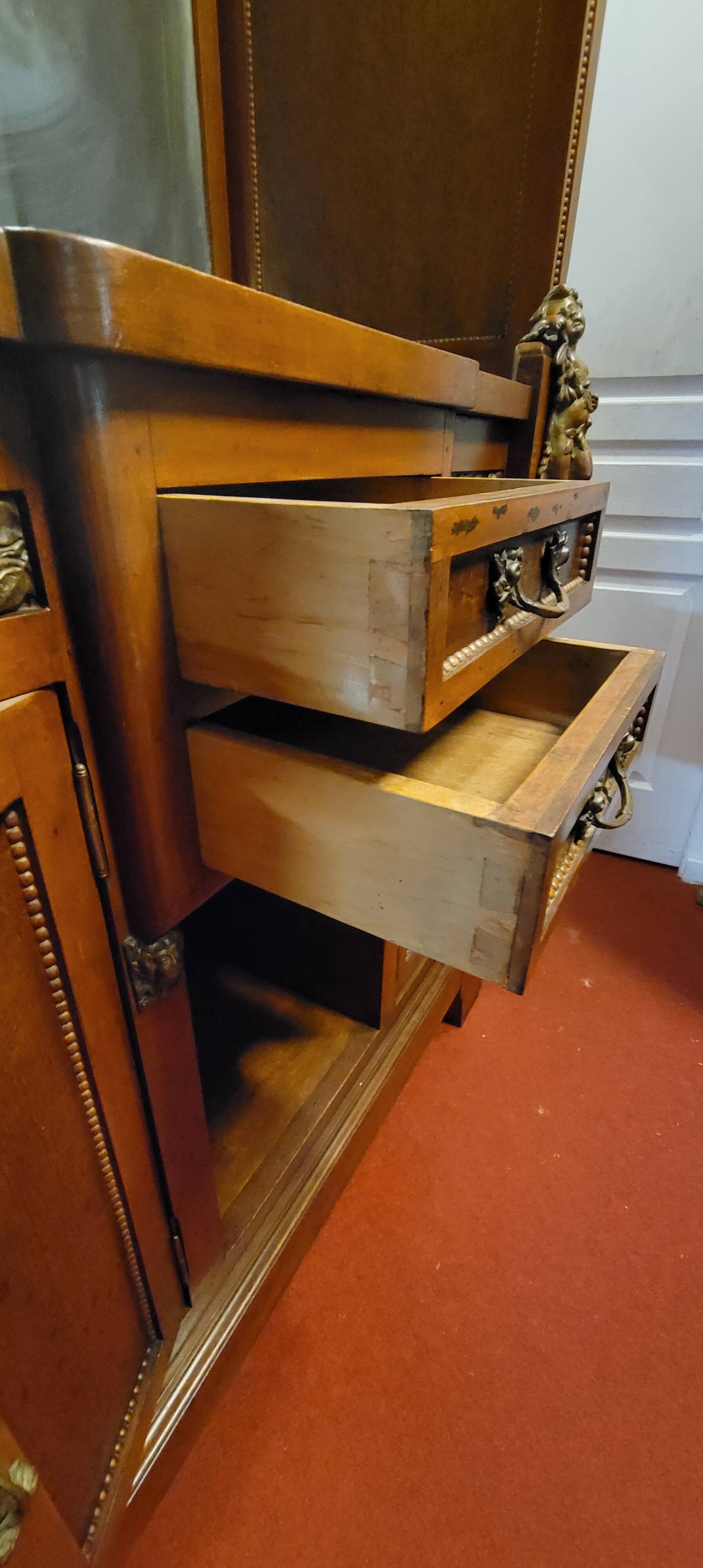 Empire style half-moon shaped mahogany bookcase with putti
