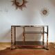 Service table with vintage brass wheels / smoked glass