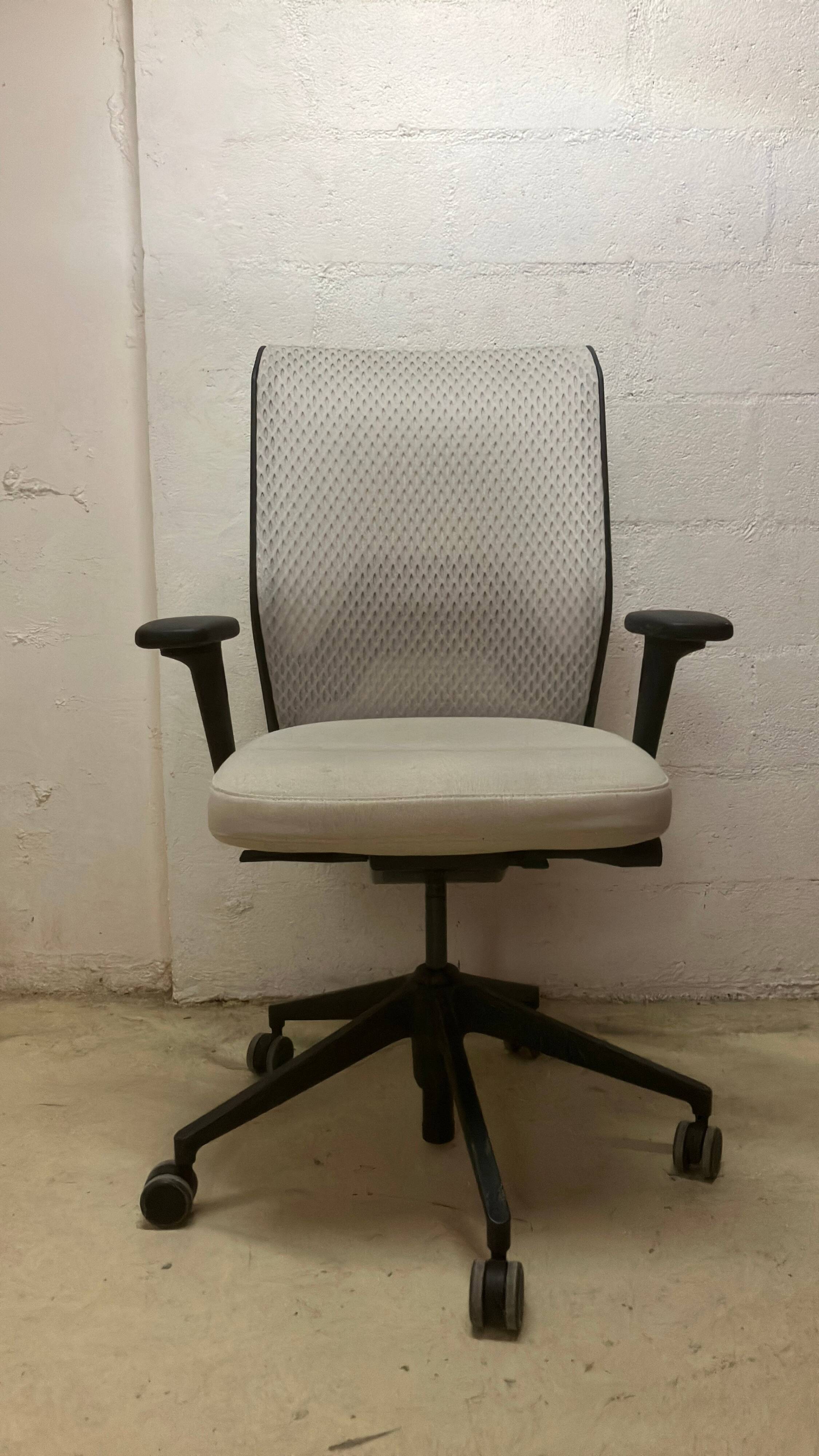 Office chair with wheels and mesh backrest.
