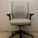 Office chair with wheels and mesh backrest.