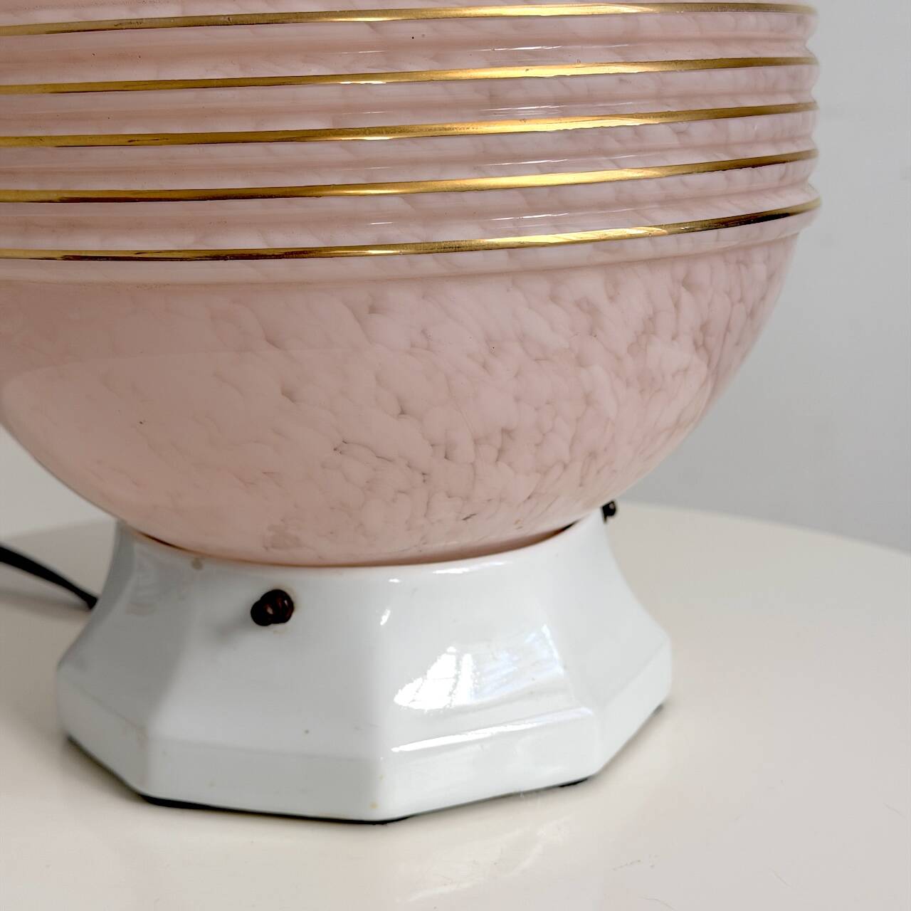 Art Deco lamp with a speckled pink glass globe and a white ceramic base.