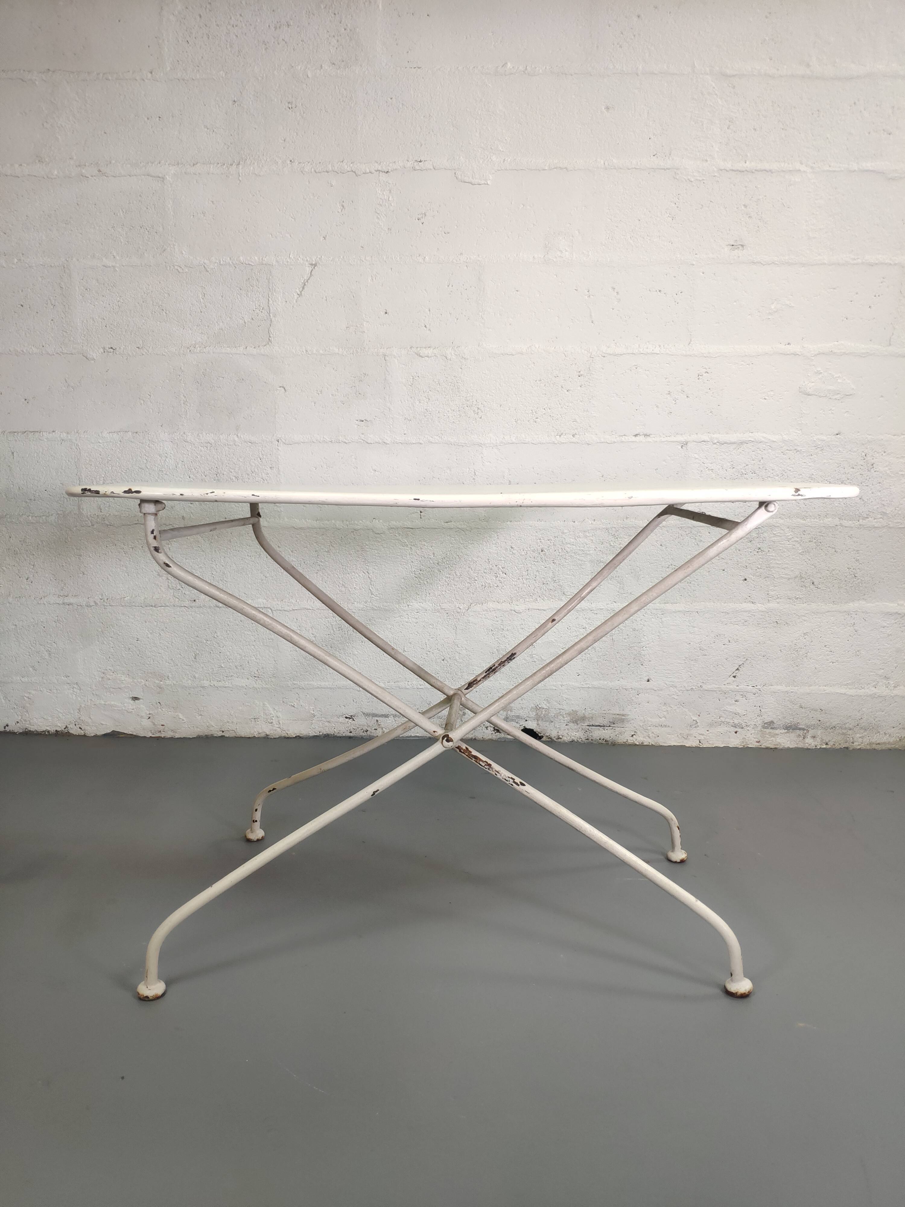 Old folding garden table in white wrought iron