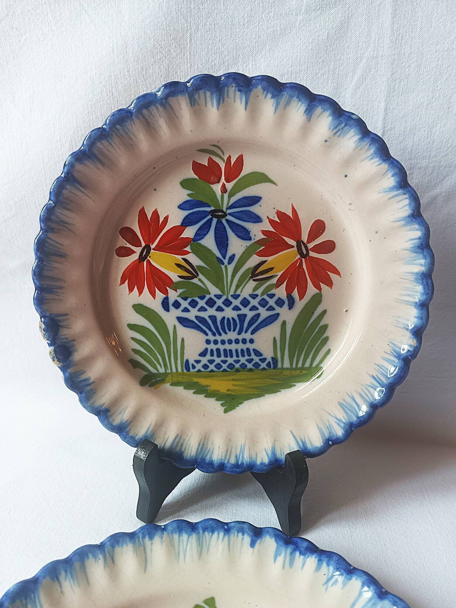Pair of antique plates in popular earthenware with a floral basket decoration on the edge.
