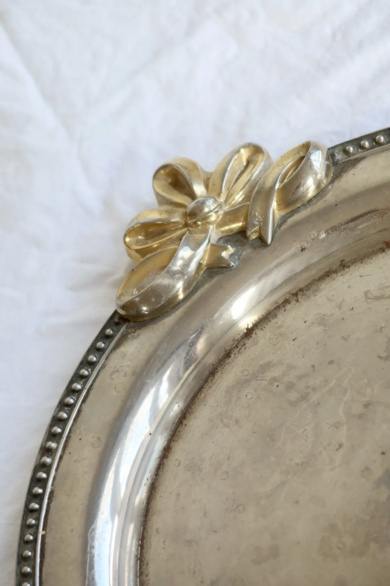 Vintage silver-plated serving tray with bow handles.