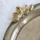 Vintage silver-plated serving tray with bow handles.