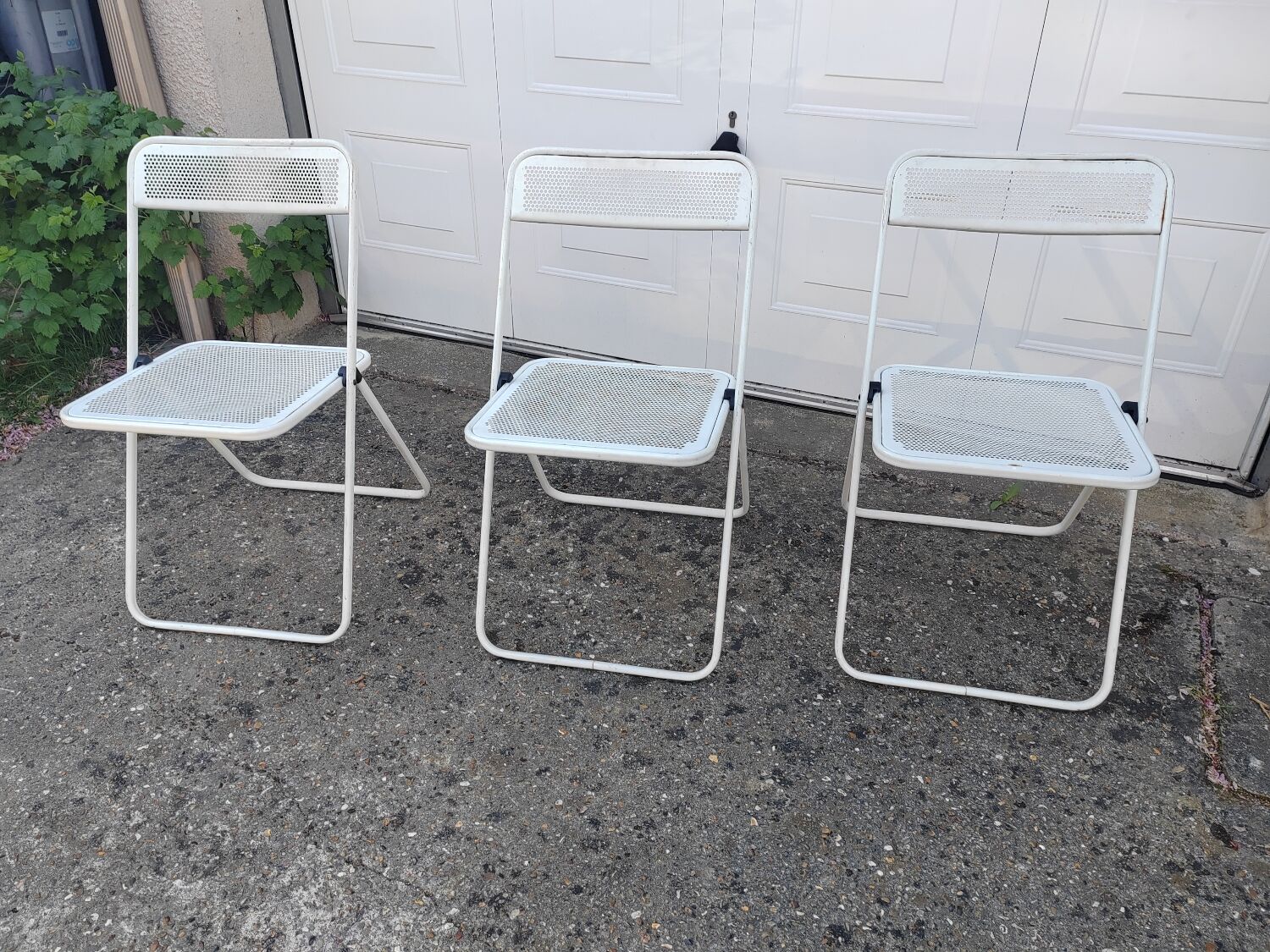 Set of three folding chairs with perforated metal.