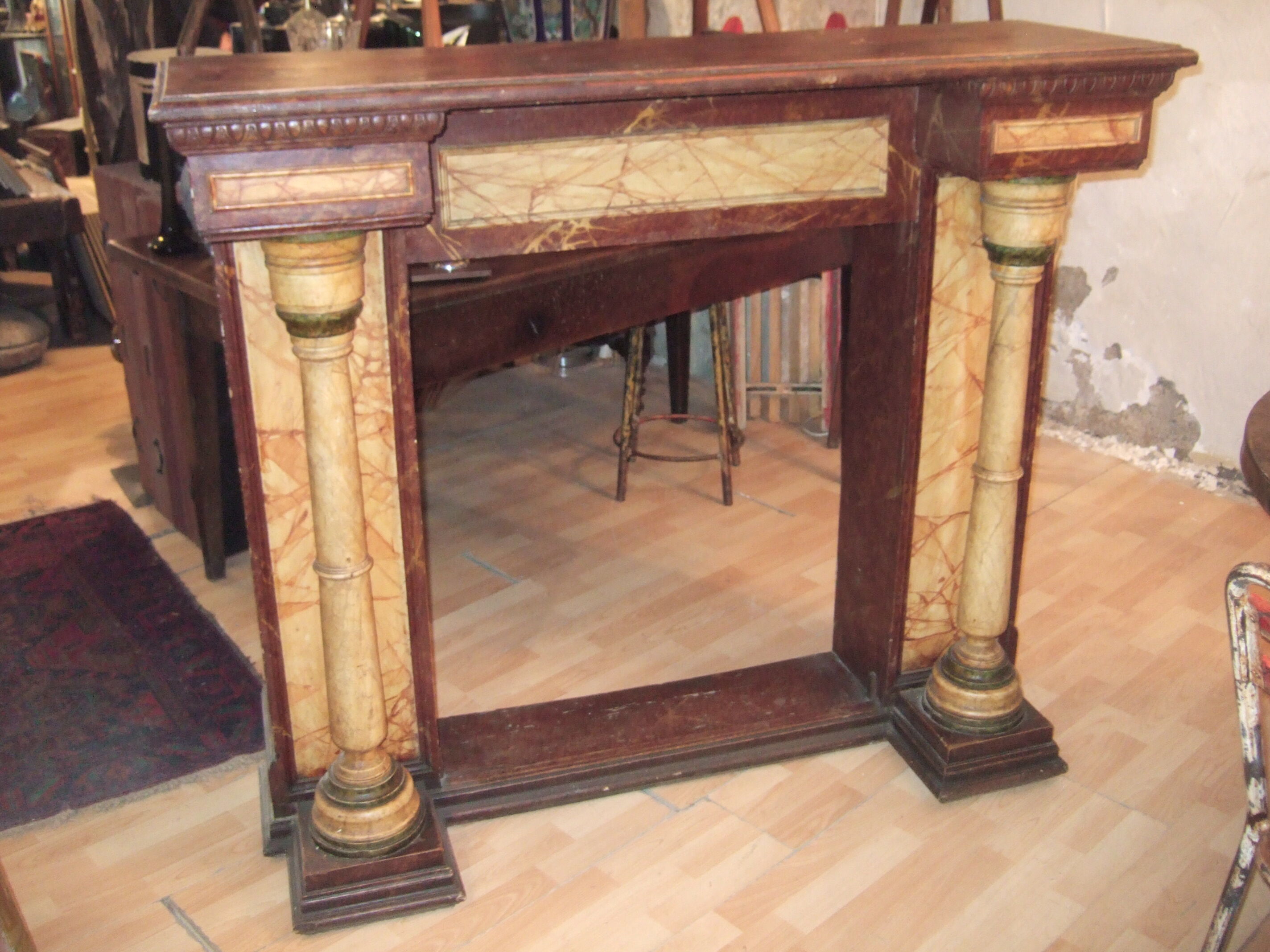 19th century wooden fireplace, faux marble paint. Can act as a console.